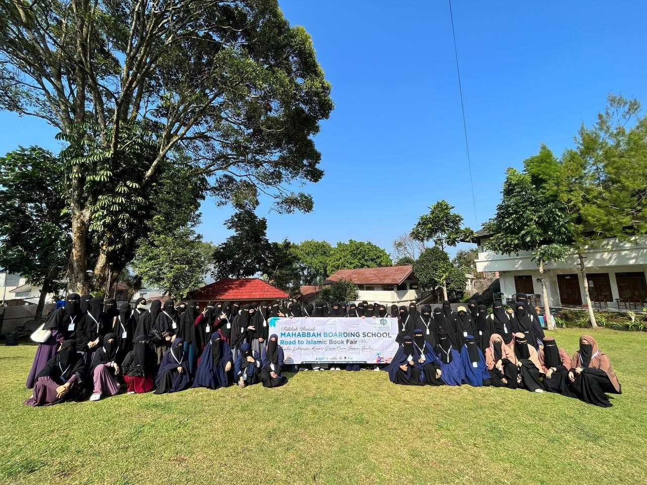 Foto bersama rombongan rihlah ilmiah Mahabbah Boarding School di halaman berumput kampus