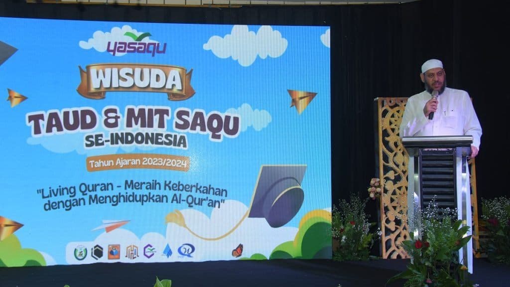 Sambutan di podium Wisuda TAUD dan MIT SAQU se-Indonesia dengan latar spanduk acara
