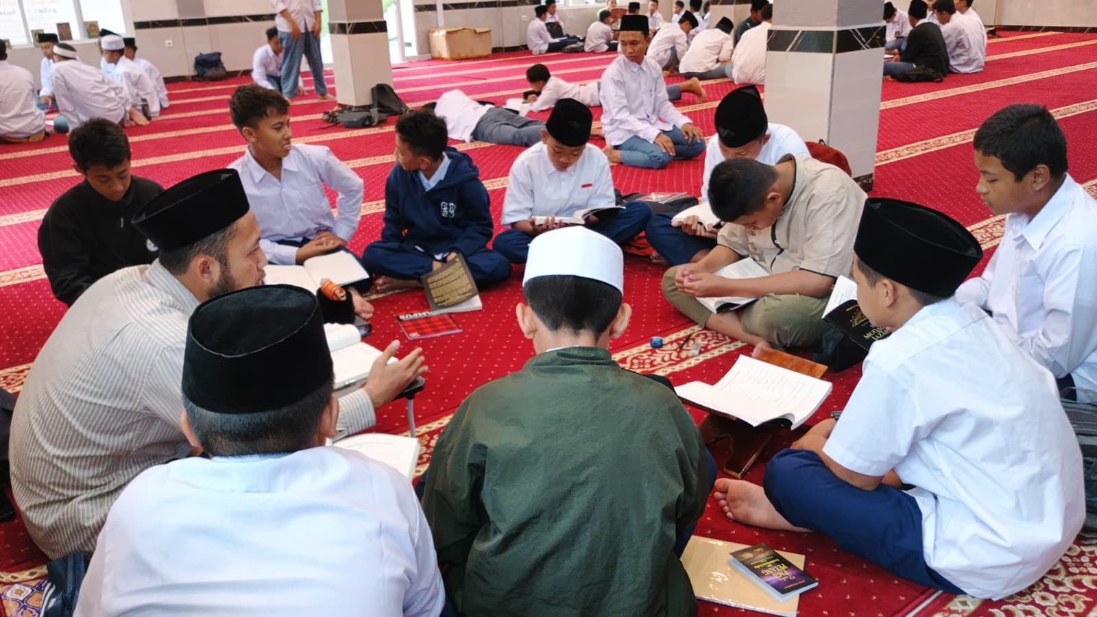 Ustadz menerangkan isi kitab kepada santri MTs Wadi Mubarak dalam halaqah di masjid