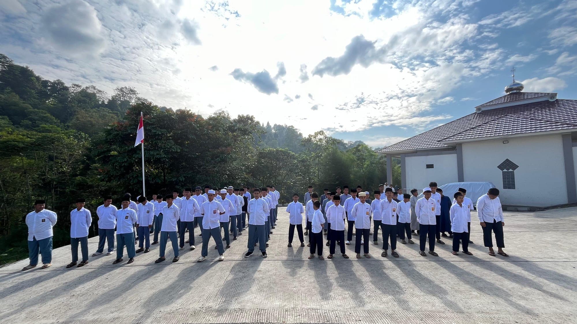 Santri MTs dan MA Wadi Mubarak berbaris pada apel pagi di halaman masjid kampus Megamendung