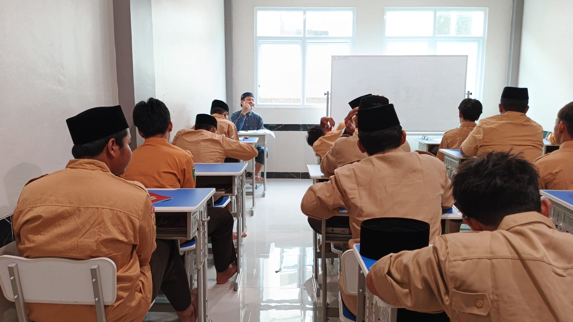 Santri MTs dan MA Wadi Mubarak berseragam pramuka mengikuti pelajaran yang dipandu ustadz dari depan kelas