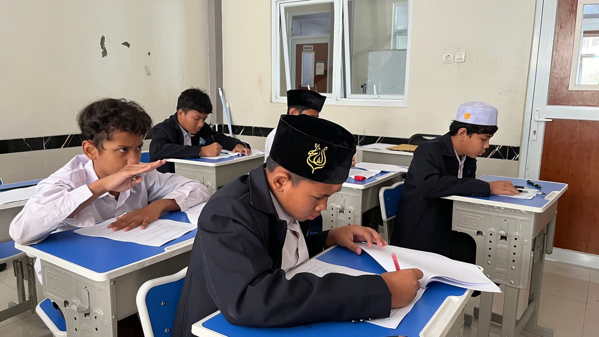 Santri MTs dan MA Wadi Mubarak mengerjakan lembar soal di ruang kelas
