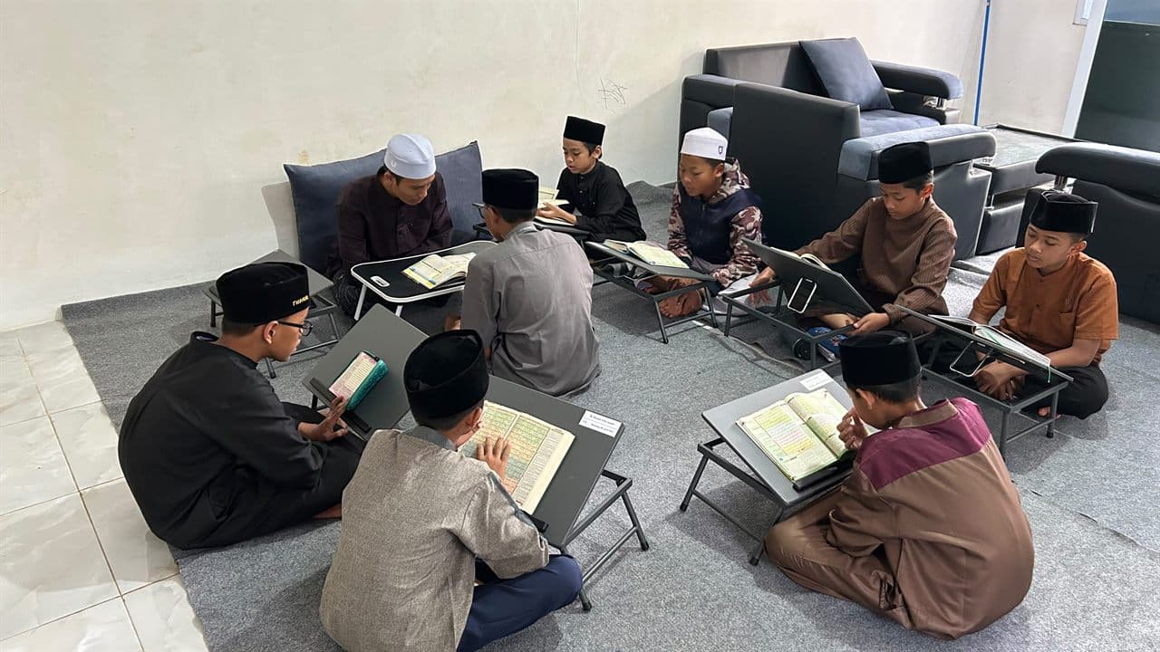 Santri Program Kaderisasi Muhaffizh membaca mushaf di atas rihal dalam halaqah melingkar