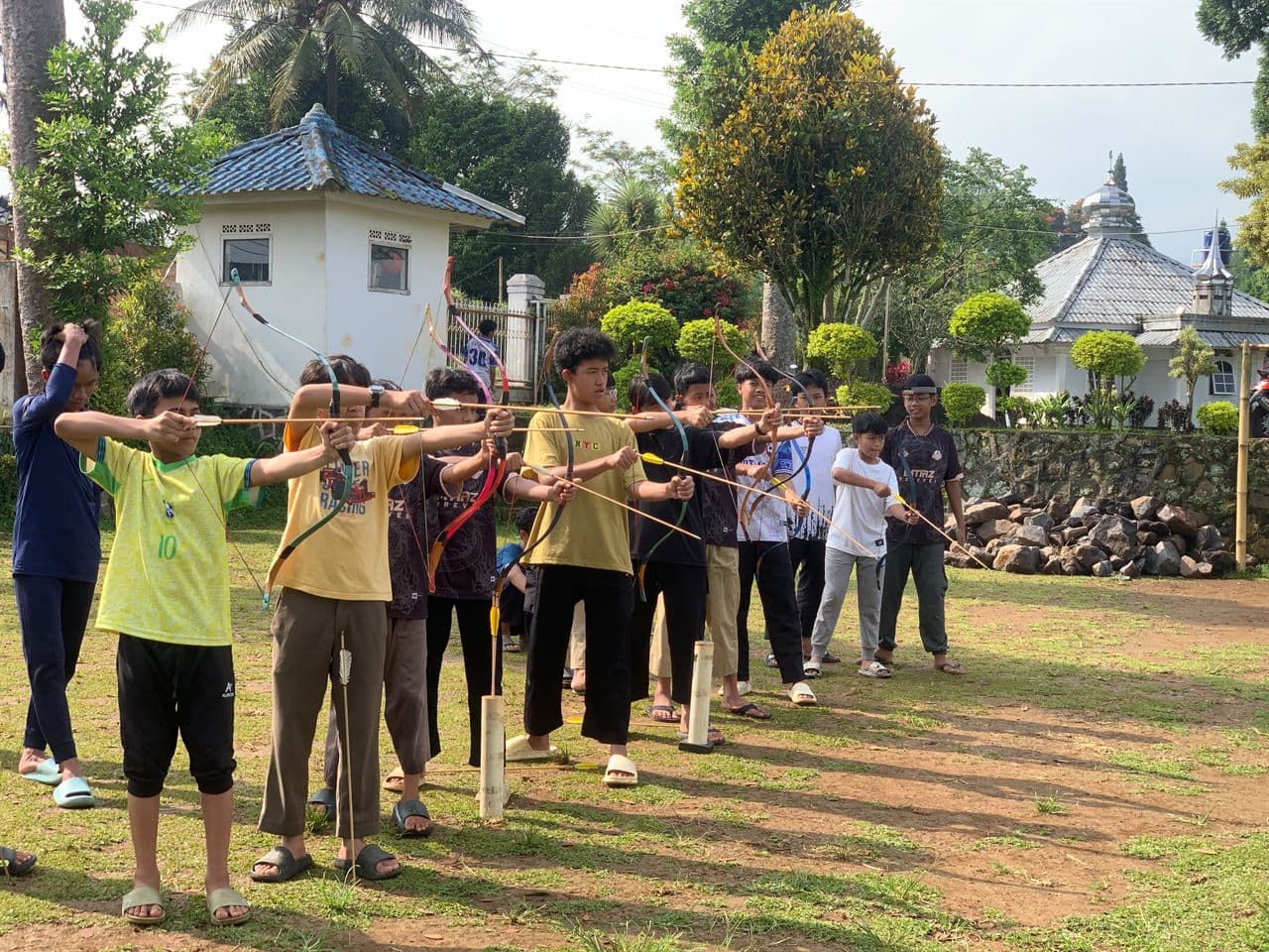 Santri Program Kaderisasi Muhaffizh berlatih memanah berjajar di halaman pondok