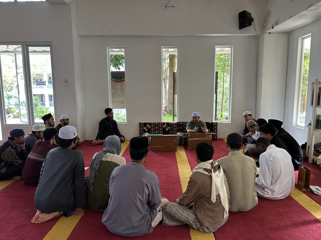 Ujian Al-Qur'an semester ganjil STIU Wadi Mubarak: mahasiswa duduk melingkar menghadap meja penguji
