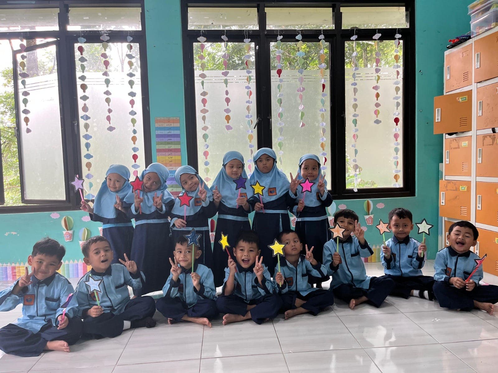Satu kelas TAUD SAQU berfoto bersama di ruang kelas berhias karya anak