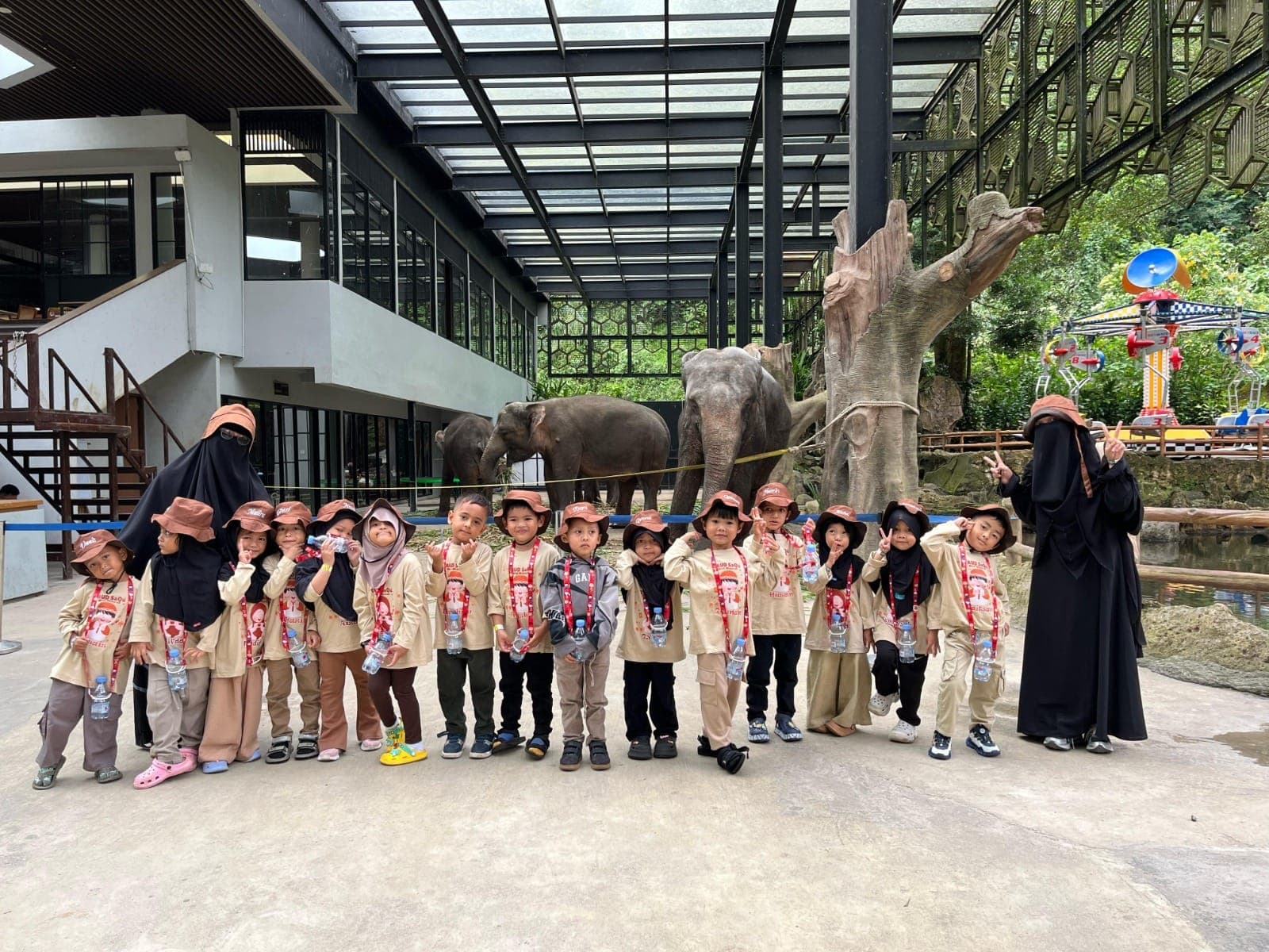 Anak-anak TAUD SAQU berfoto bersama guru di depan kandang gajah saat rihlah ke kebun binatang