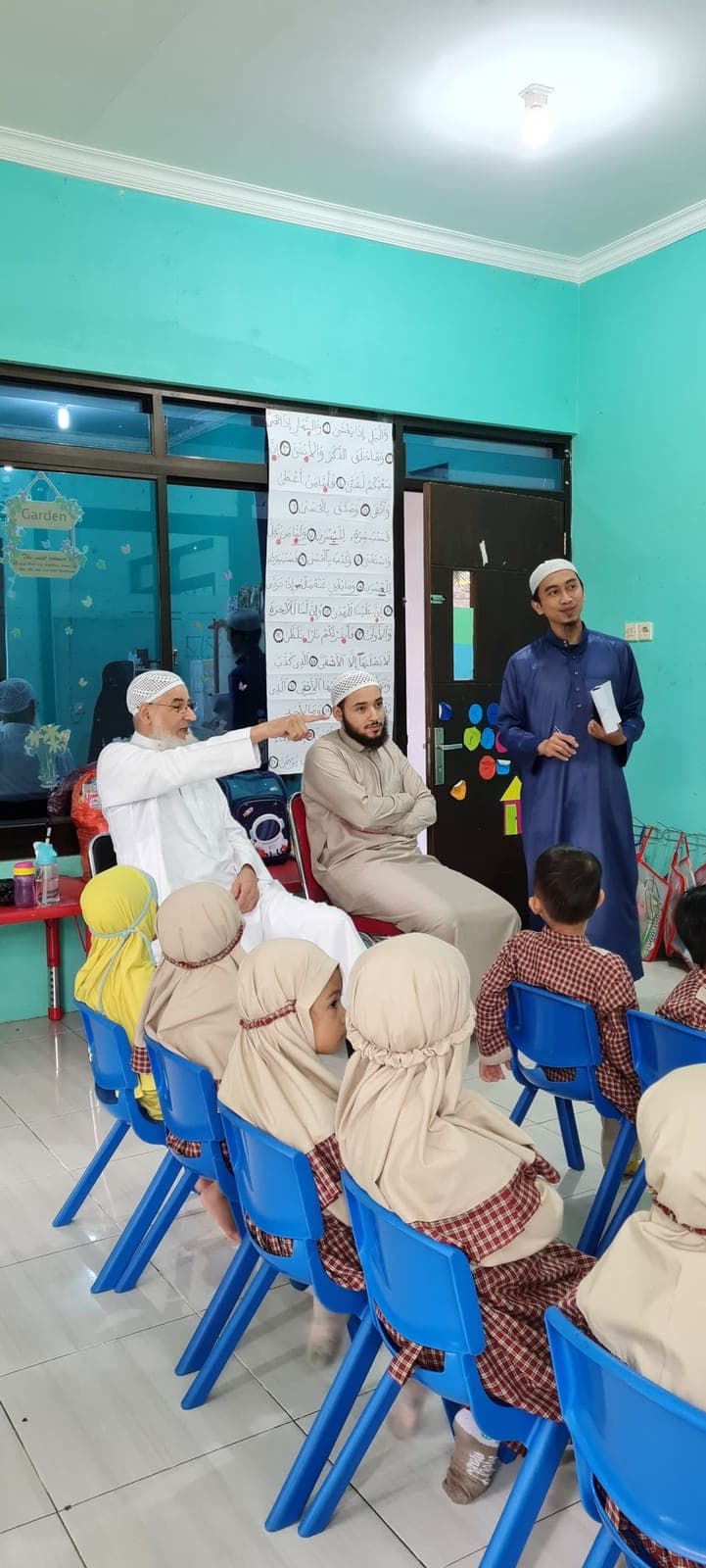 Anak-anak TAUD SAQU duduk menyimak ustadz tamu yang berkunjung ke kelas